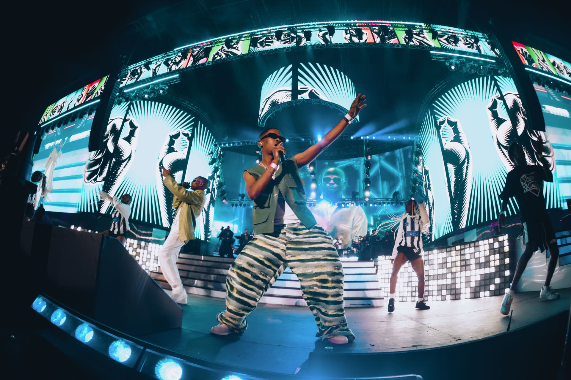 Performer and dancers on the illuminated stage
