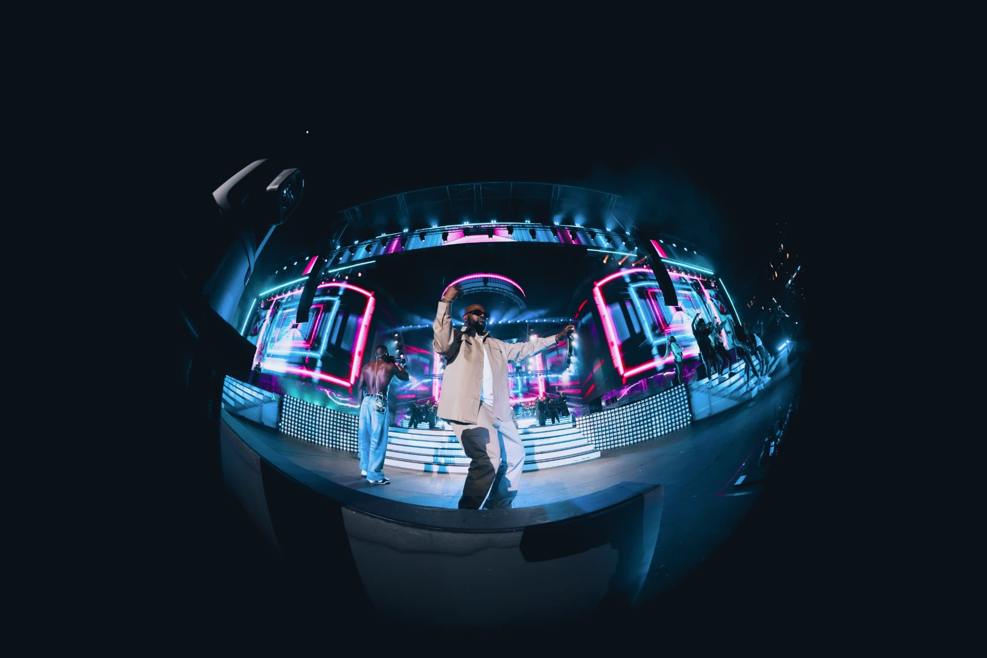 Performer dancing on the neon-lit stage