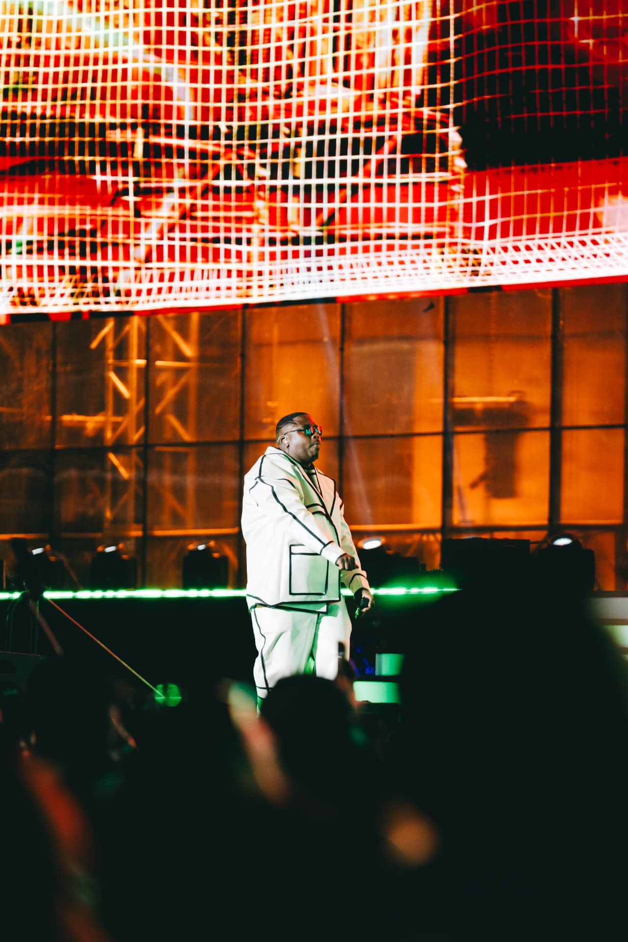 Performer on stage in front of the fiery orange screen