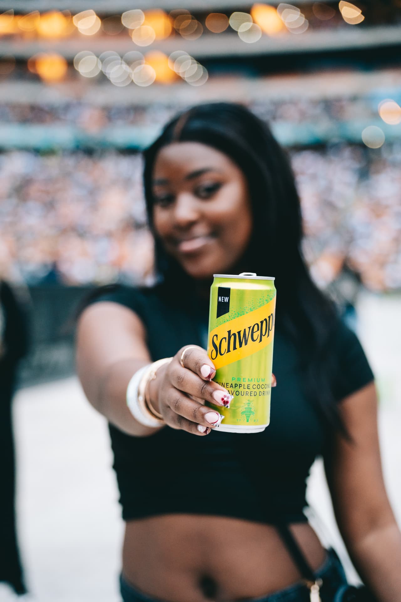 Guest presenting a Schweppes drink in the stadium
