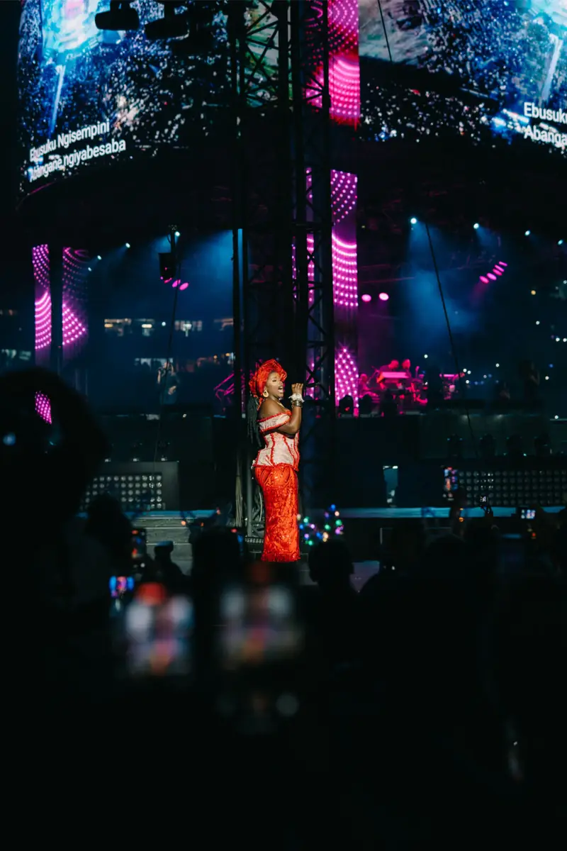 Vocalist in red performing under stadium lights