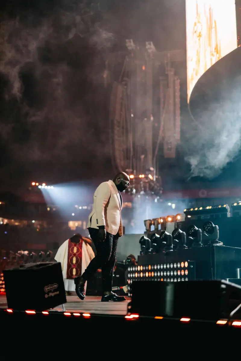 Artist walking the main stage in a cream jacket